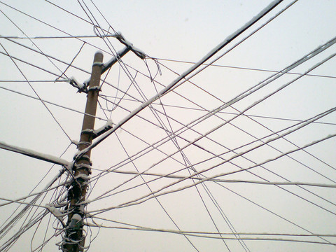 雪后掛滿積雪的電線桿和電線