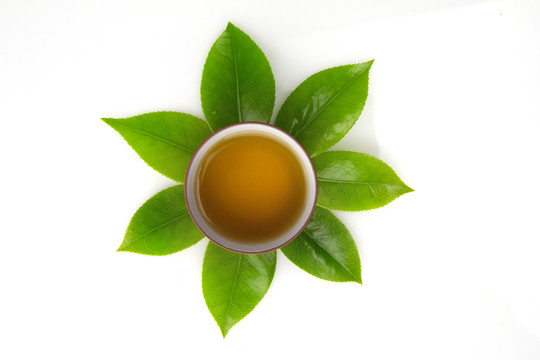 綠色茶葉與茶杯