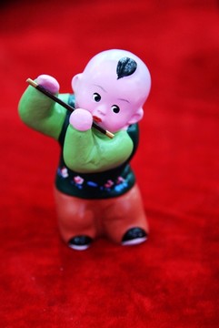 泥塑彩繪吹笛子的娃娃