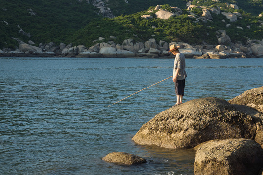 海邊巖石上的垂釣者