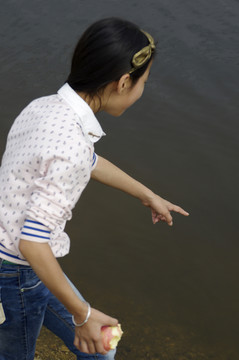 池塘邊指魚(yú)給你看的女孩