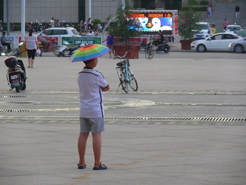 頭頂雨傘的男孩背影