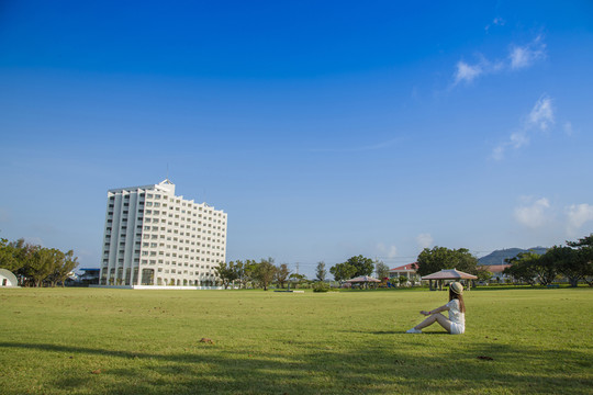 美麗的女孩坐在風(fēng)景區(qū)的草坪上
