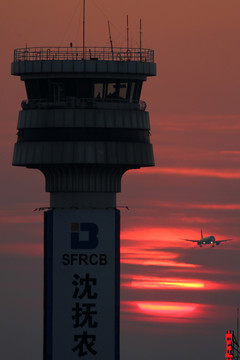 夕陽中的塔臺和飛機降落