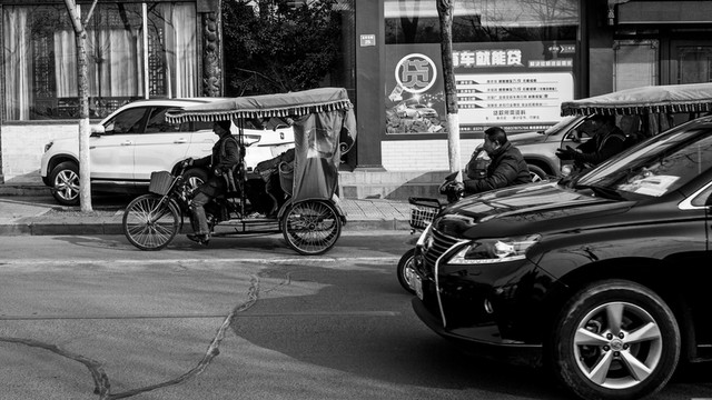現(xiàn)代與傳統(tǒng) 人力三輪車和汽車