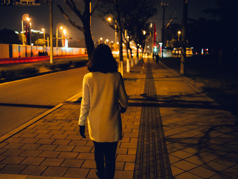 夜晚白衣少女走在人行道