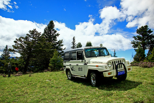 藍天白云草原下的JEEP越野車