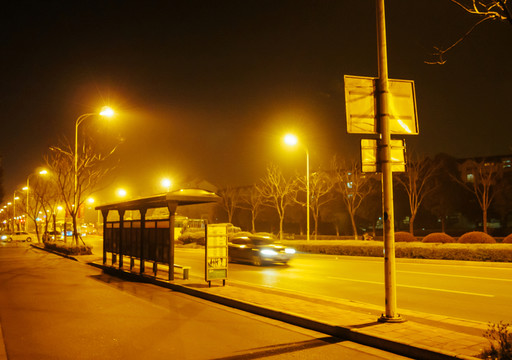 汽車飛馳而過公交車站牌 夜景