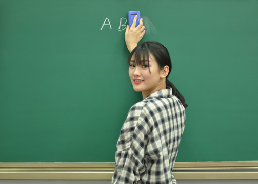 正在擦黑板的女教師