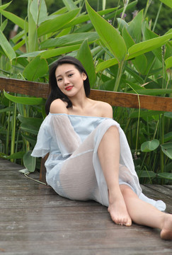 蹲坐在戶外木板上的年輕女人