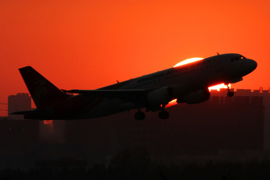 穿過(guò)夕陽(yáng)的飛機(jī)