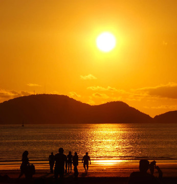 海灘上的人們在美麗的金色夕陽下