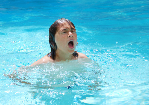 小男孩在游泳池里游泳