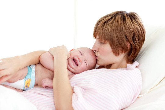 母親吻她的新生嬰兒