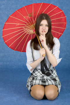 在藍(lán)色背景上有一把紅色雨傘的女孩