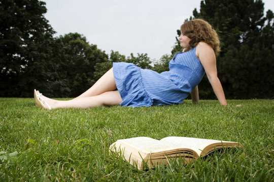 在草地上放松的女孩與書