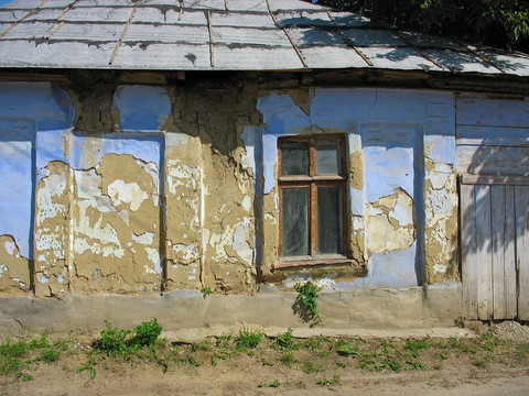 老式的窗口；旧的棕色和蓝色的墙壁；废弃的房子