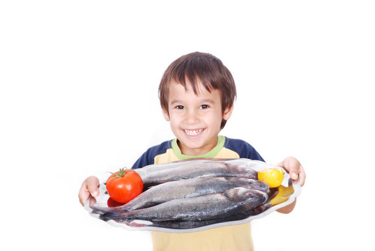 面帶微笑的孩子在桌子上的新鮮魚