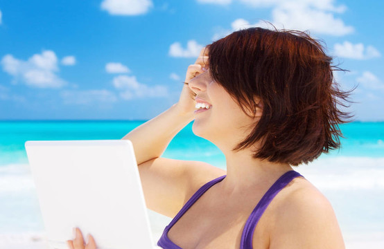 海灘上帶著筆記本電腦的女人