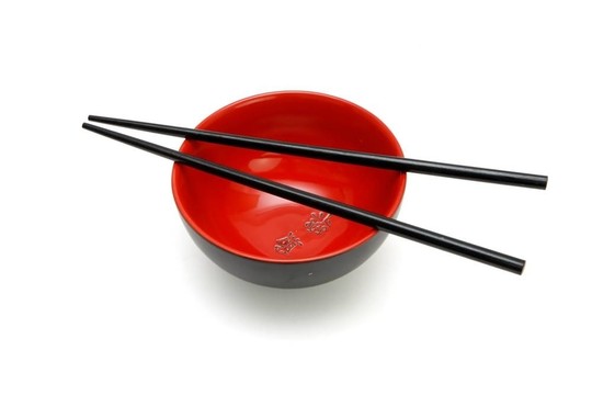 筷子在紅色和黑色的日本碗孤立