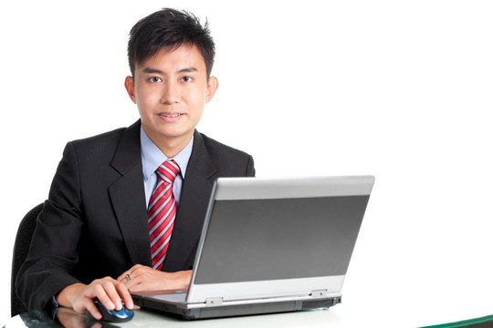 成功的亞洲商人在書桌與筆記本電腦
