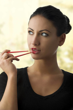 迷人的女人用筷子