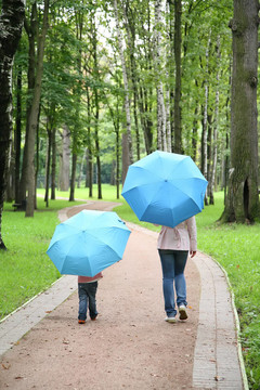 母親帶著孩子在公園的傘下
