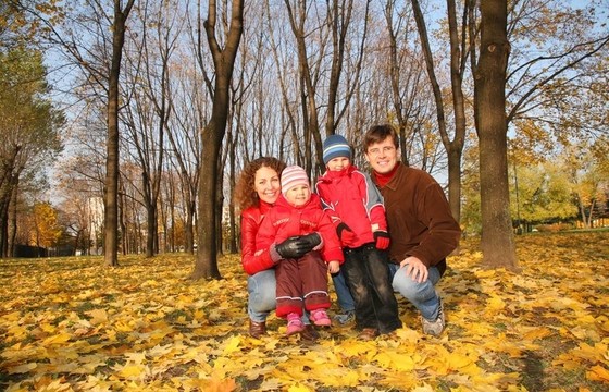 母親和父親在秋天與孩子們在公園