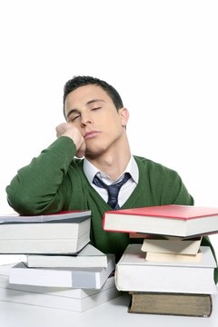 男學(xué)生在書桌上堆書睡覺