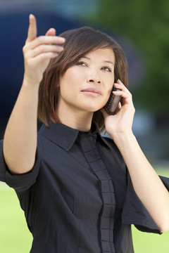 一個美麗的東方東方中國女人在她的手機上聊天和指點。