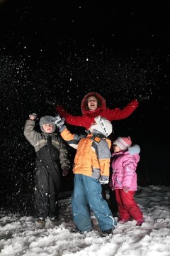 孩子和母親在夜晚扔雪