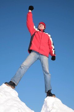 男子在紅色上衣頂部的雪山與手