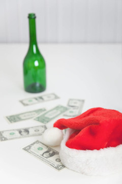 白桌子上的瓶子；圣诞帽和钱