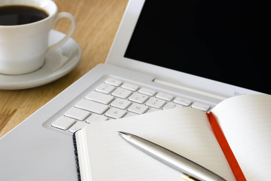 白色笔记本电脑和咖啡杯