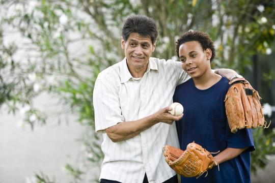 西班牙裔父親與African American十幾歲的兒子舉行棒球和手套
