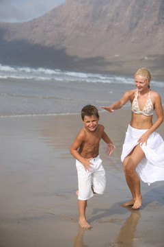 在海滩上的快乐的母亲和儿子