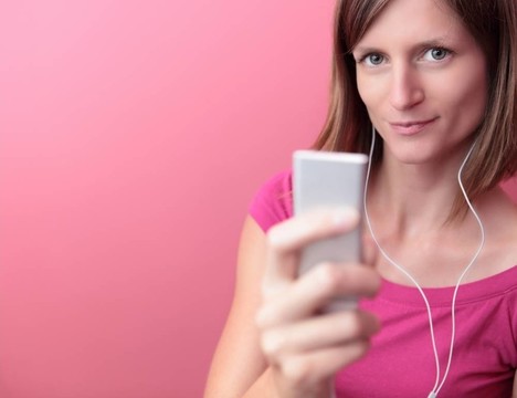 年輕漂亮的女人在她的便攜式MP3播放器聽(tīng)音樂(lè)