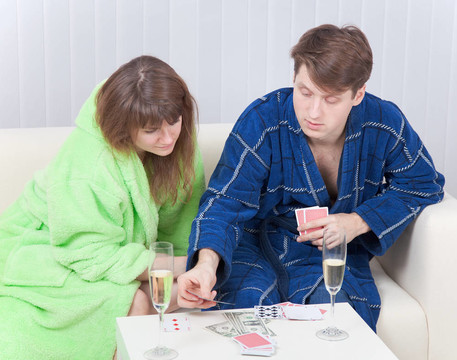 一對年輕夫婦在一張沙發(fā)上玩紙牌