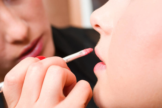 這女孩的嘴唇用紅色唇膏美容師。