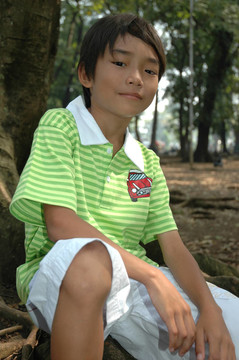 小男孩坐在樹旁