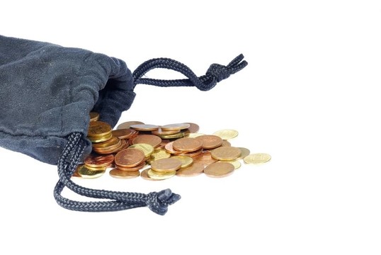 最后幾枚金屬硬幣從袋子里掉了出來.…可憐的經(jīng)濟(jì)。白色隔離