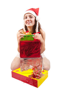 性感的黑發(fā)女人在圣誕老人的帽子坐在散落在她赤裸的圣誕禮物