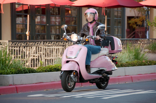 女士騎車上粉色的滑板車