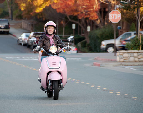 女士騎車上粉色的滑板車