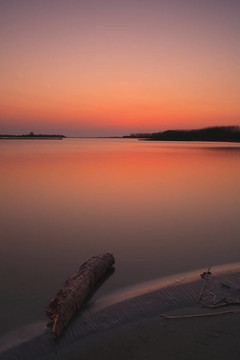 海灘上寧?kù)o的夕陽(yáng)，海上有一片紅色的天空