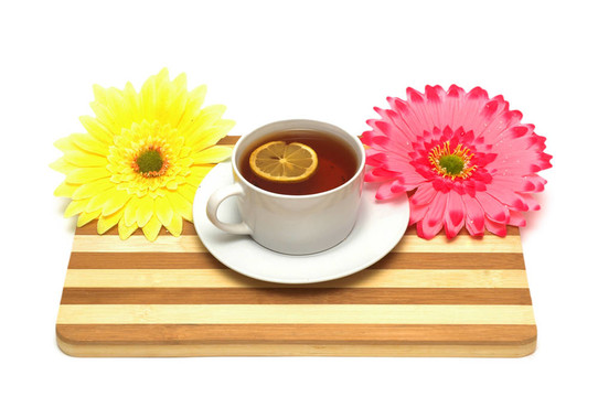 一杯茶在木板上和花上