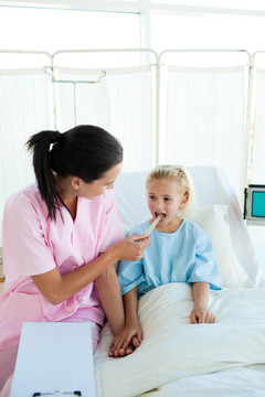 有吸引力的护士检查一个小女病人
