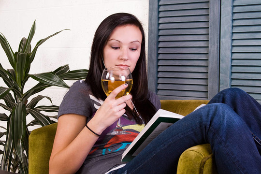 可爱的女孩在看书的时候喝酒