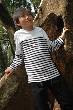 小男孩站在樹旁