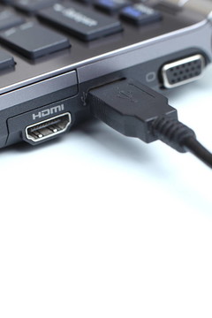 一個USB電纜插入到現(xiàn)代高端筆記本電腦的USB端口特寫細節(jié)視圖